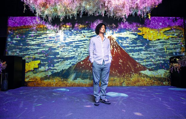 圖為Ryotaro身處「FLOWERS BY NAKED」現場，站在其中一幅作品前，名為「360° Around Mt. Fuji NAKED meets北」，是以數位科技及投影技術重現浮世繪大師葛飾北齋的巔峰作《富嶽三十六景》。