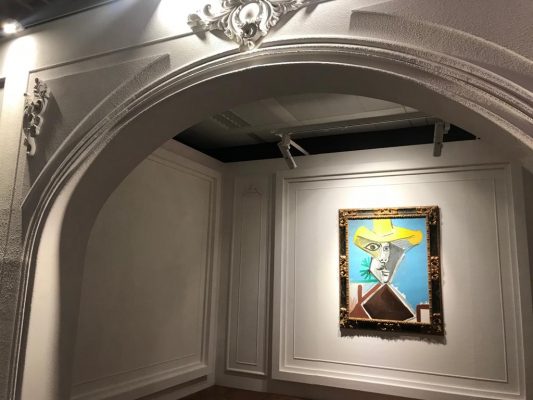 畢加索1969年作、囊括藝術家晚期作品關鍵題材的《男子半身像》，在掛畫的現場空間，是為一道拱門設計場景，此乃仿照畢卡索的工作間。